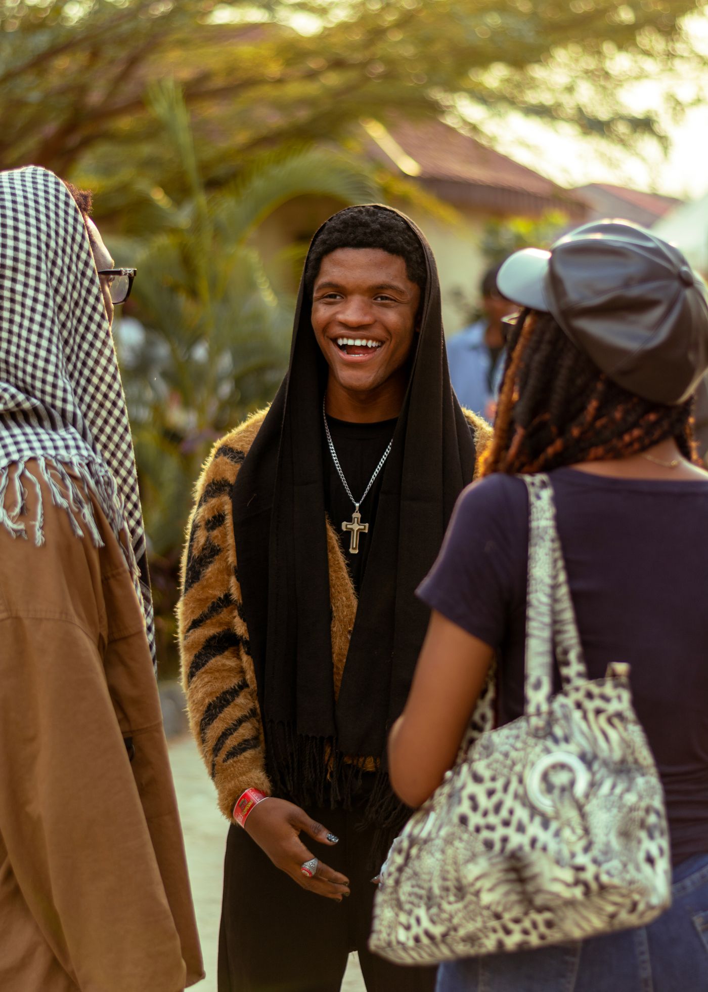 Three friends talking together outdoors at golden hour in Ado Ekiti, Nigeria