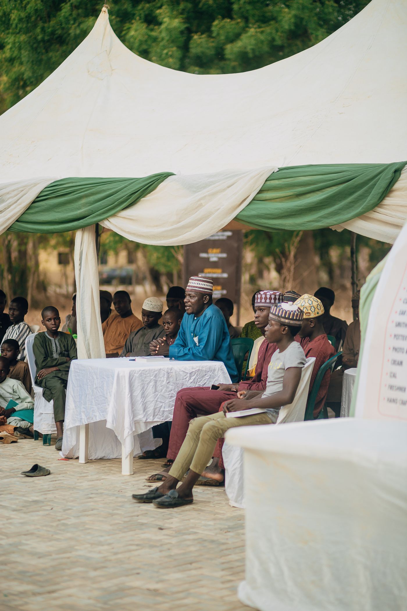 A community meeting held under a canopy in northern Nigeria