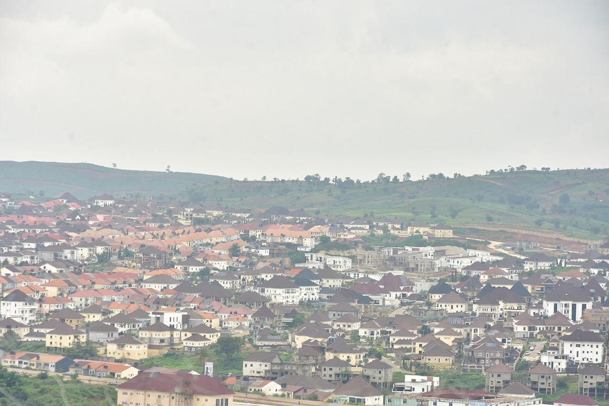 Rooftops of a residential estate in Abuja with hills behind