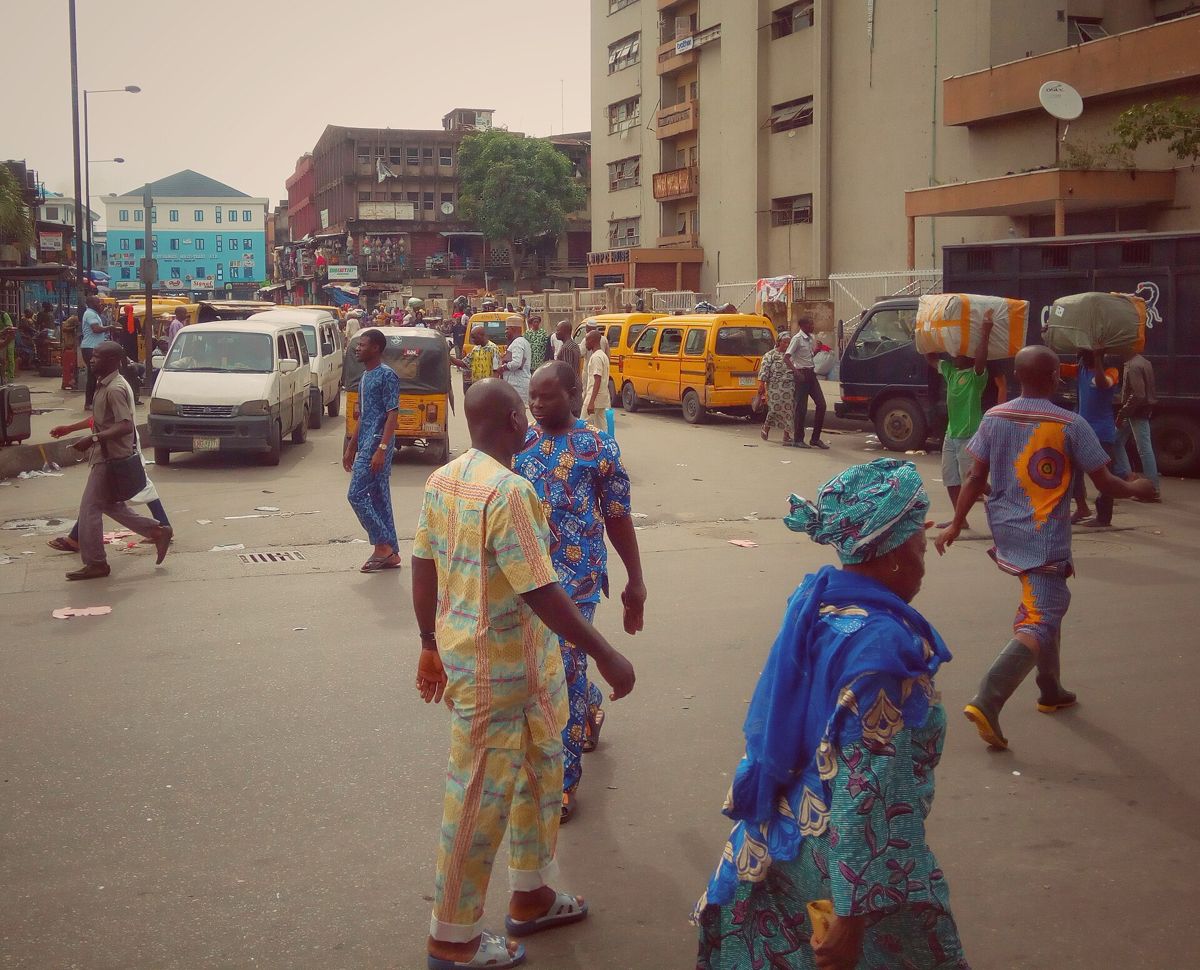 People walking through a busy street market in Lagos
